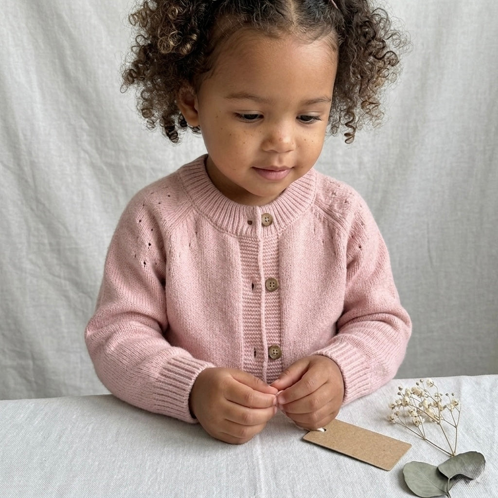 Girl wearing a pink organic cotton cardigan