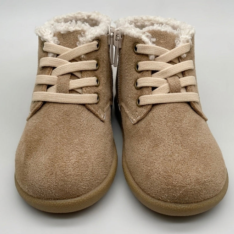 Pair of beige boots with white fur lining on a light gray background