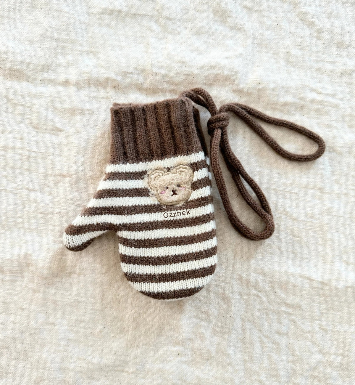 Kids winter gloves with string — brown striped single glove on cream linen | Ozznek