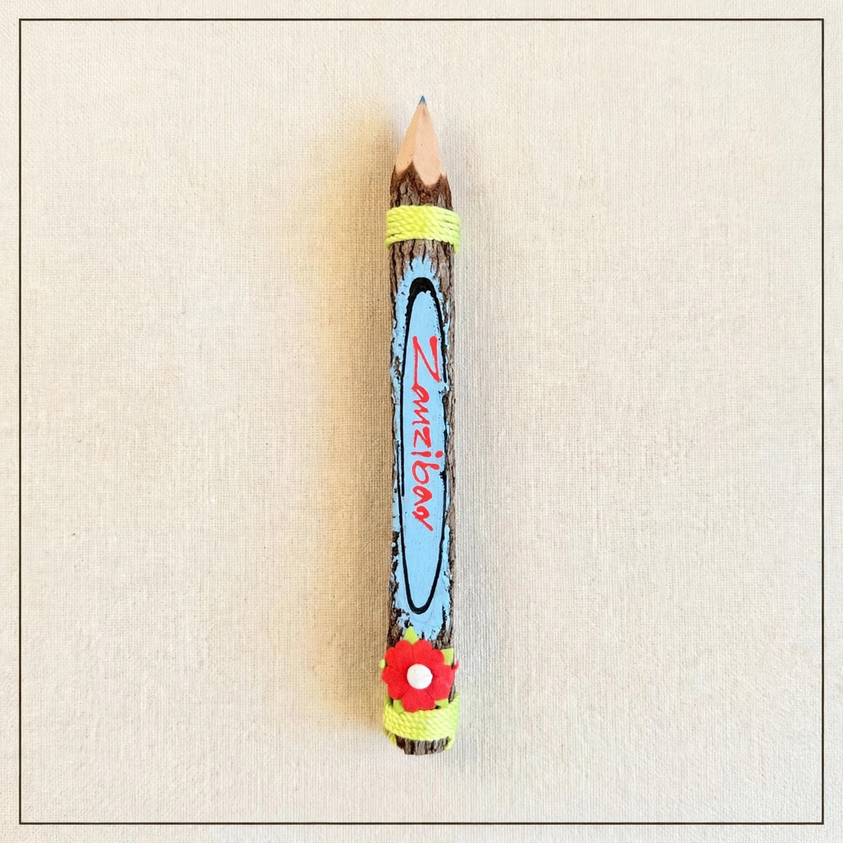 Big light blue hand-carved wooden coloring pencil with the hand-painted word Zanzibar, blue tip