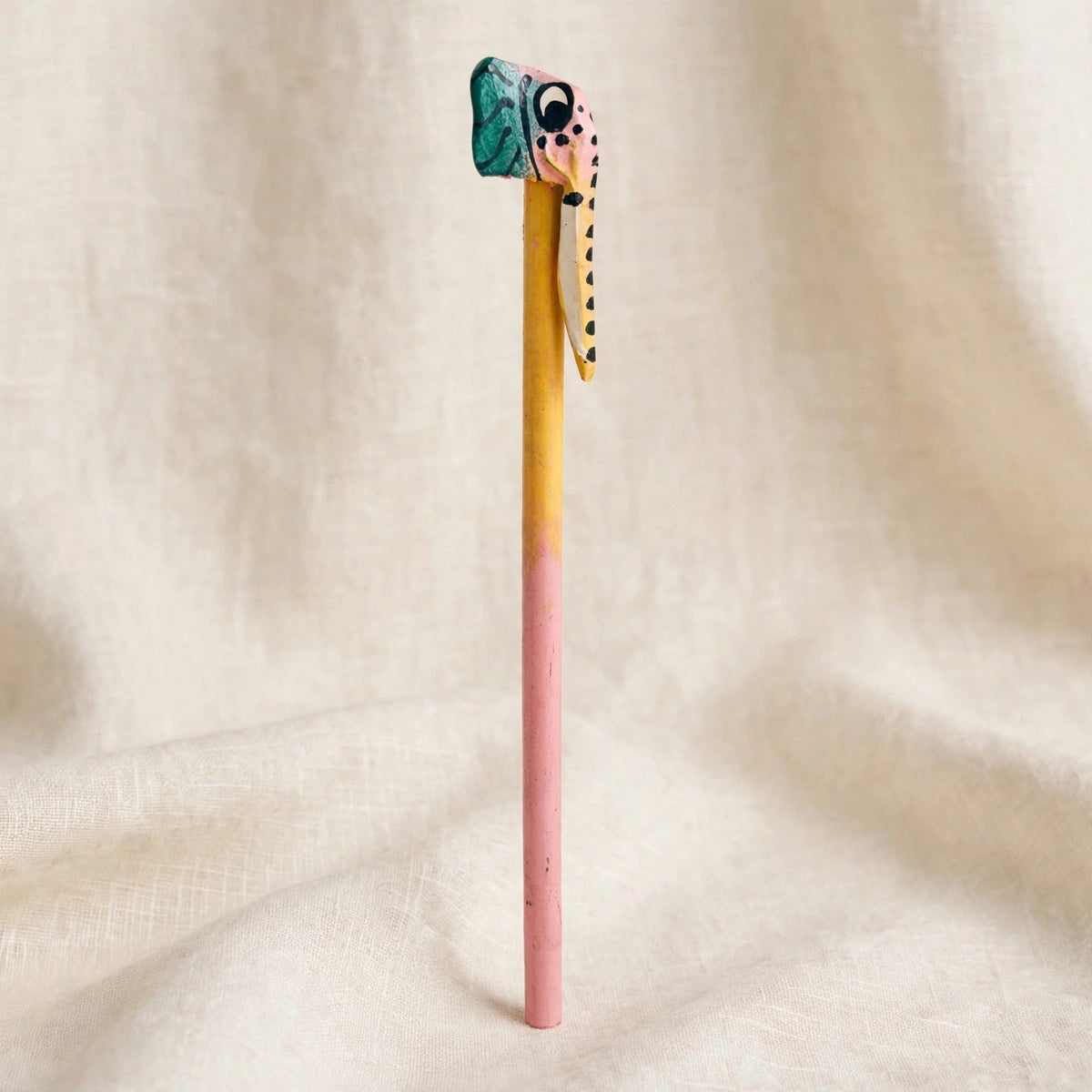 Hand-carved wooden pencil with a pink and green elephant head and trunk, handmade in Zanzibar