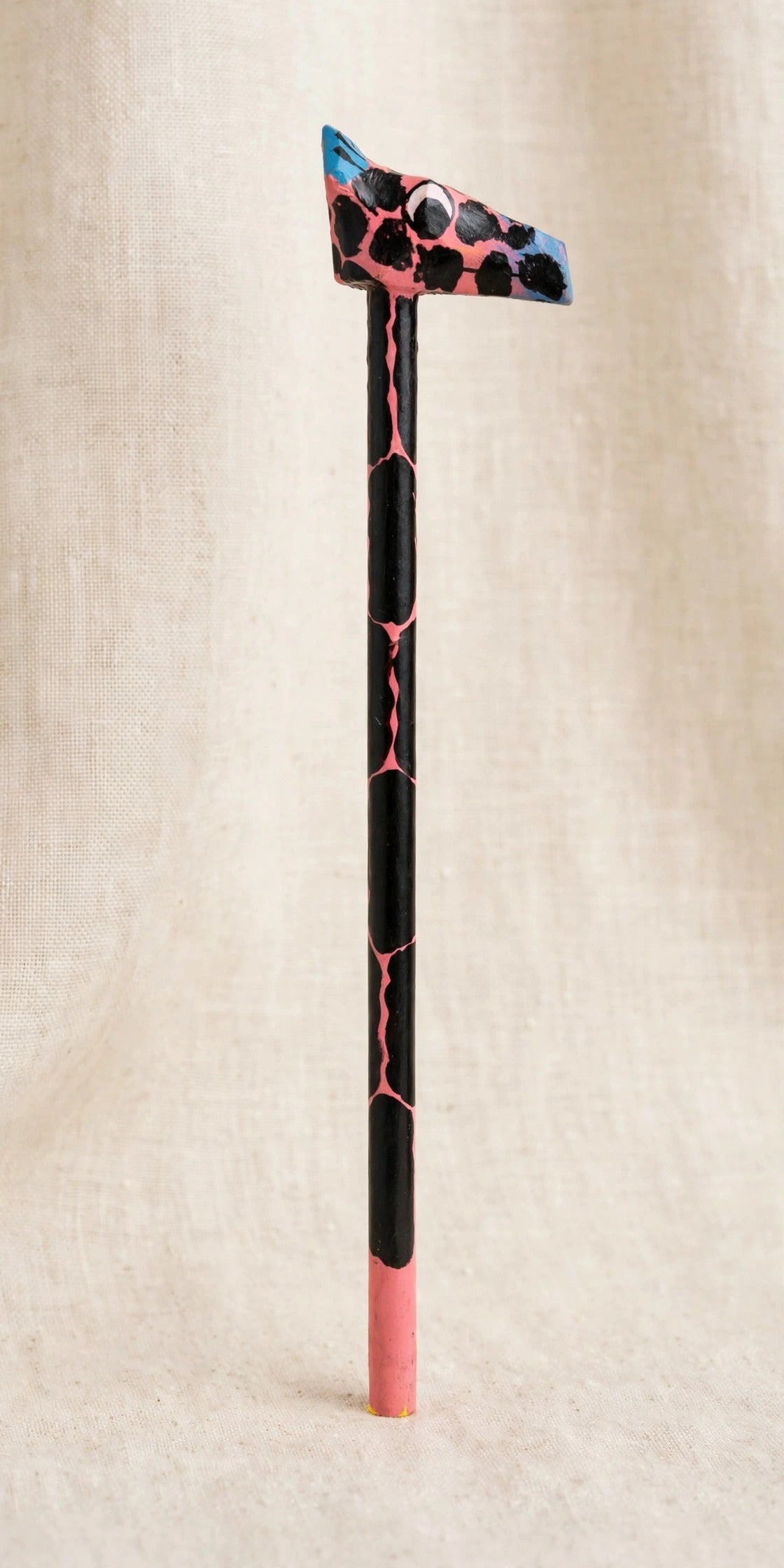 Hand-carved wooden pencil with a pink giraffe head with black spots, handmade in Zanzibar — a unique gift for kids