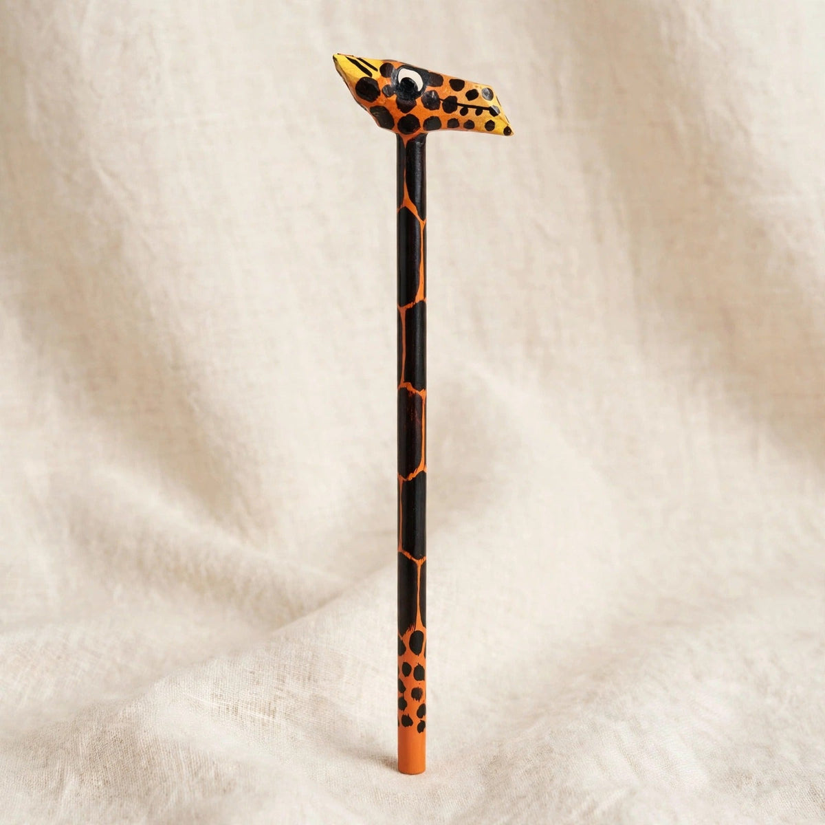 Hand-carved wooden pencil with an orange leopard head with black spots, handmade in Zanzibar