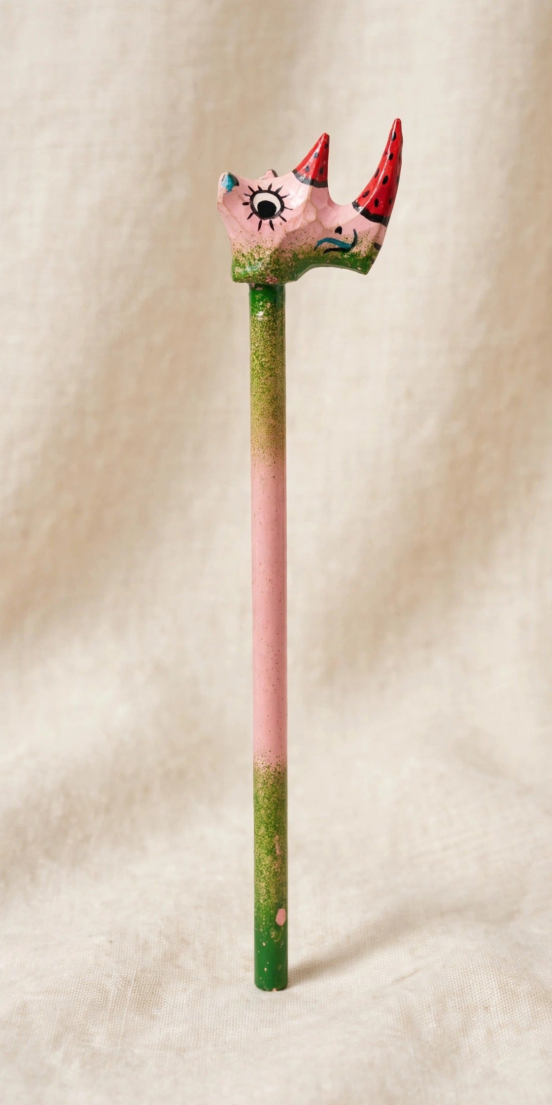 Hand-carved wooden pencil with a pink rhino head with two red horns, handmade in Zanzibar