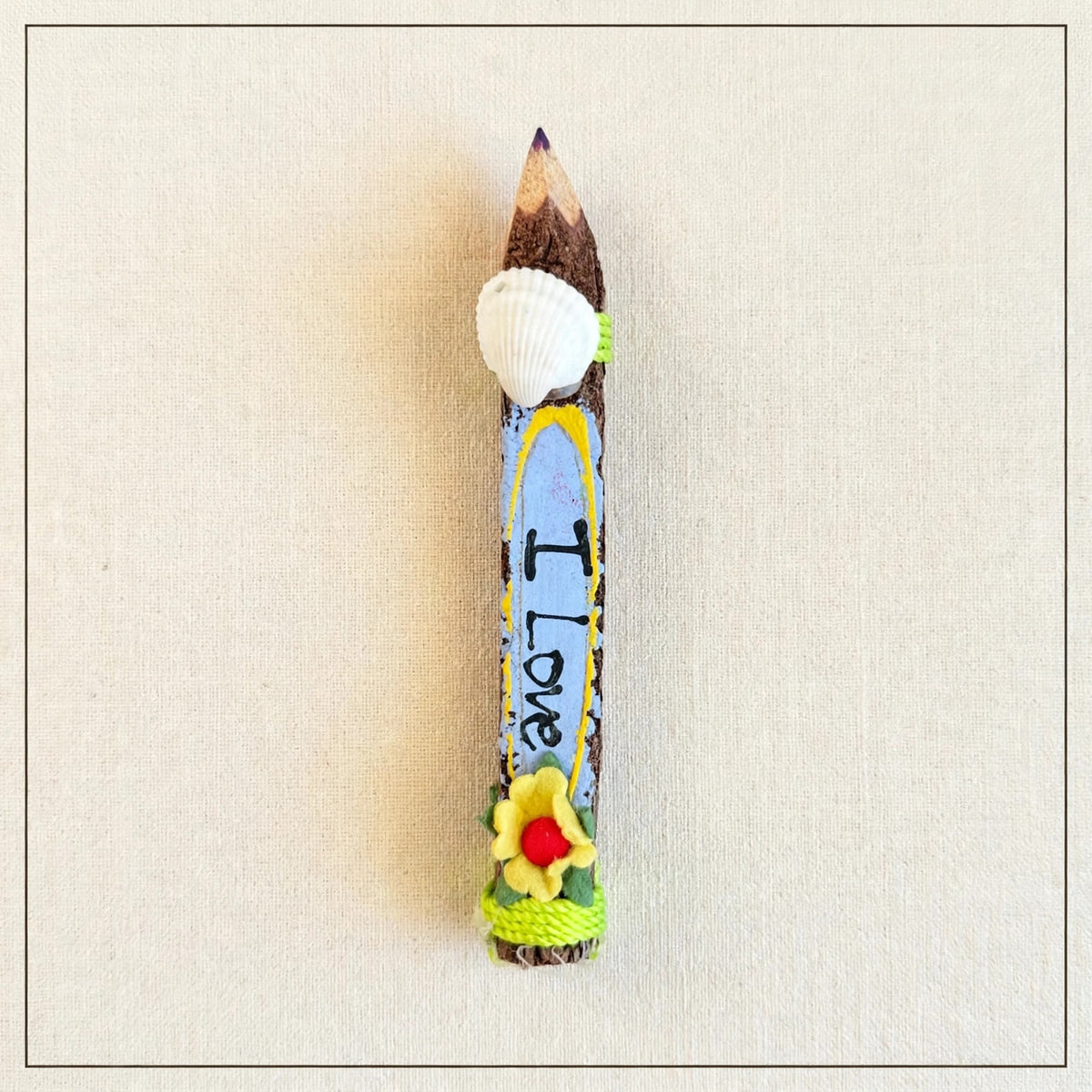 Small hand-carved wooden coloring pencil with a real seashell, purple tip and the hand-painted words I Love