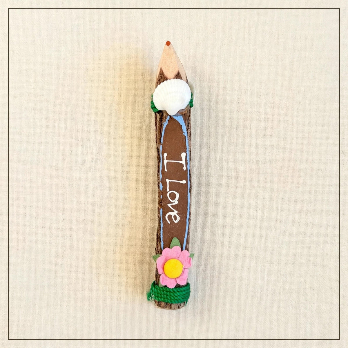 Small brown hand-carved wooden coloring pencil with a real seashell, red tip and the hand-painted words I Love