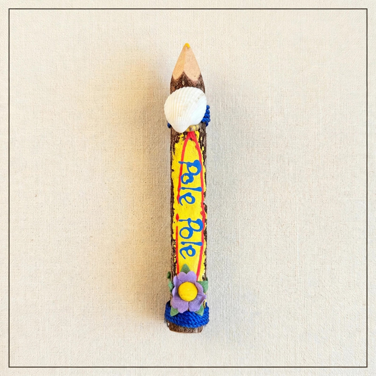 Small yellow hand-carved wooden coloring pencil with a real seashell and the hand-painted Swahili words Pole Pole