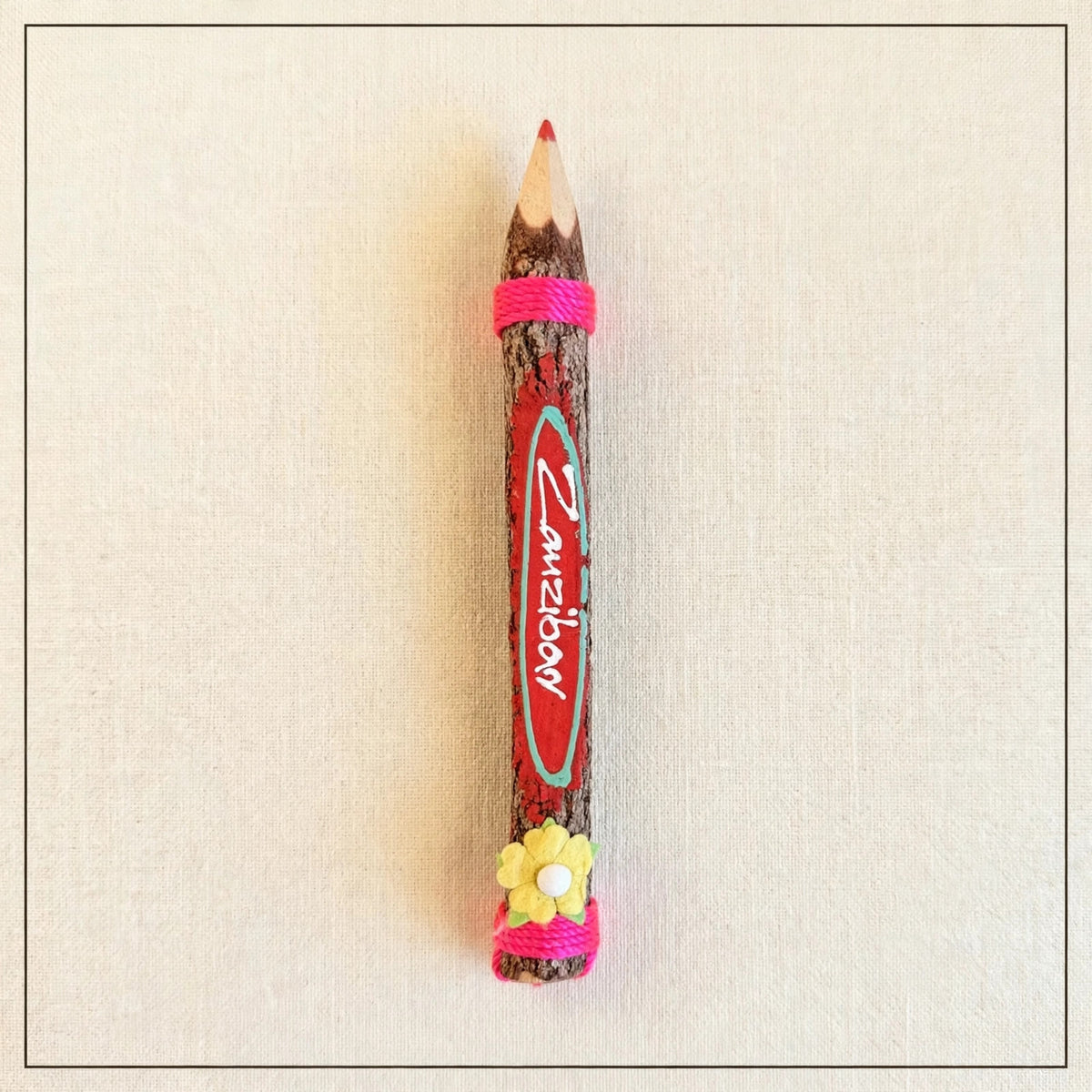 Red big hand-carved wooden coloring pencil with natural bark and the hand-painted word Zanzibar