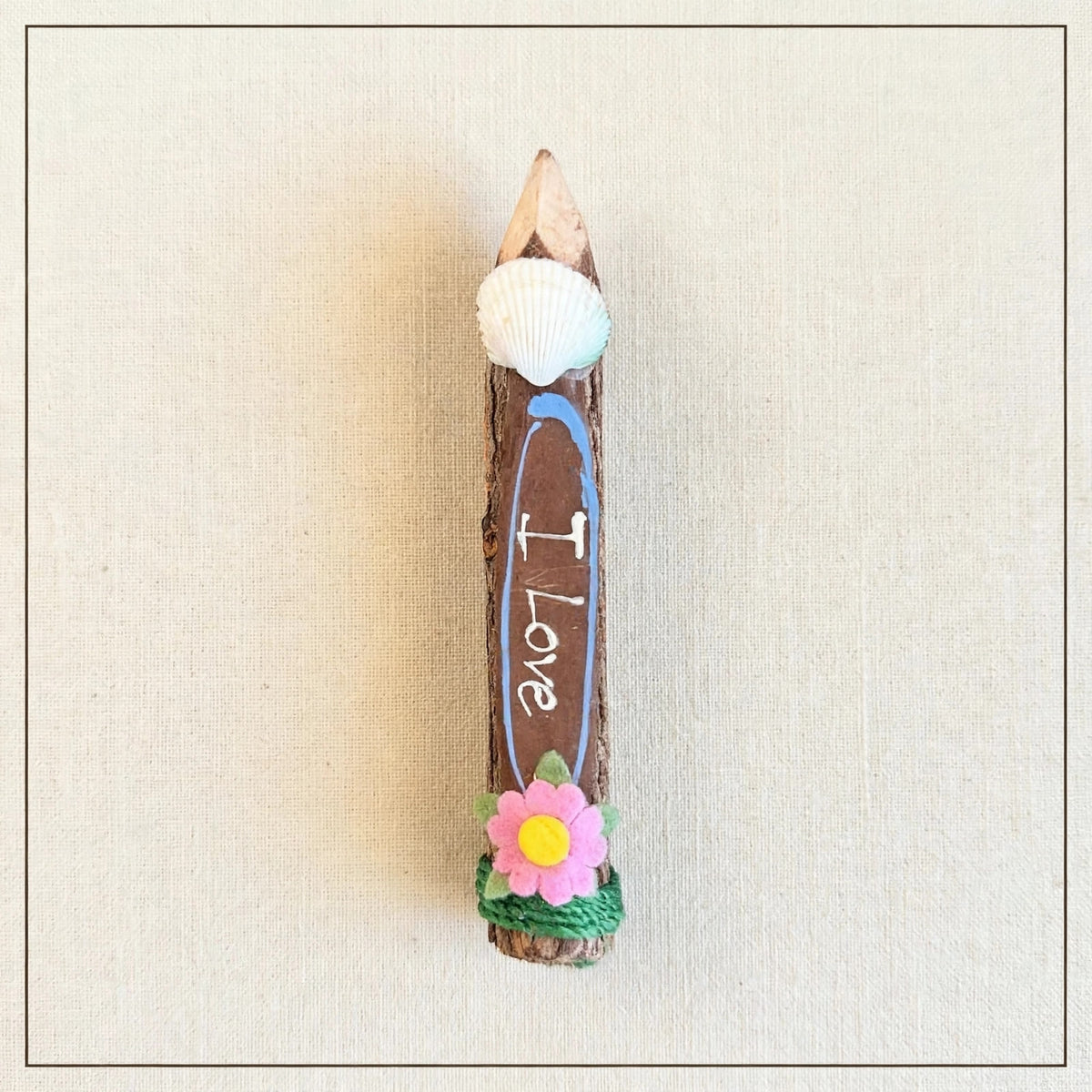 Brown small hand-carved wooden coloring pencil with a real seashell and the hand-painted words I Love