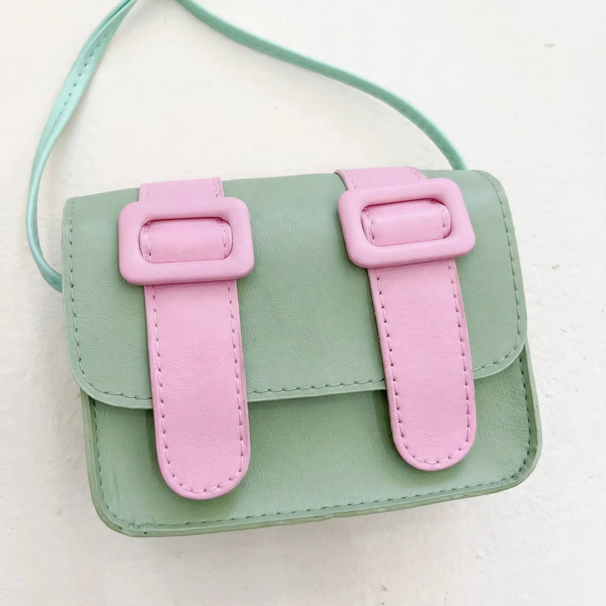 Mini satchel bag buckle detail - white studio photo